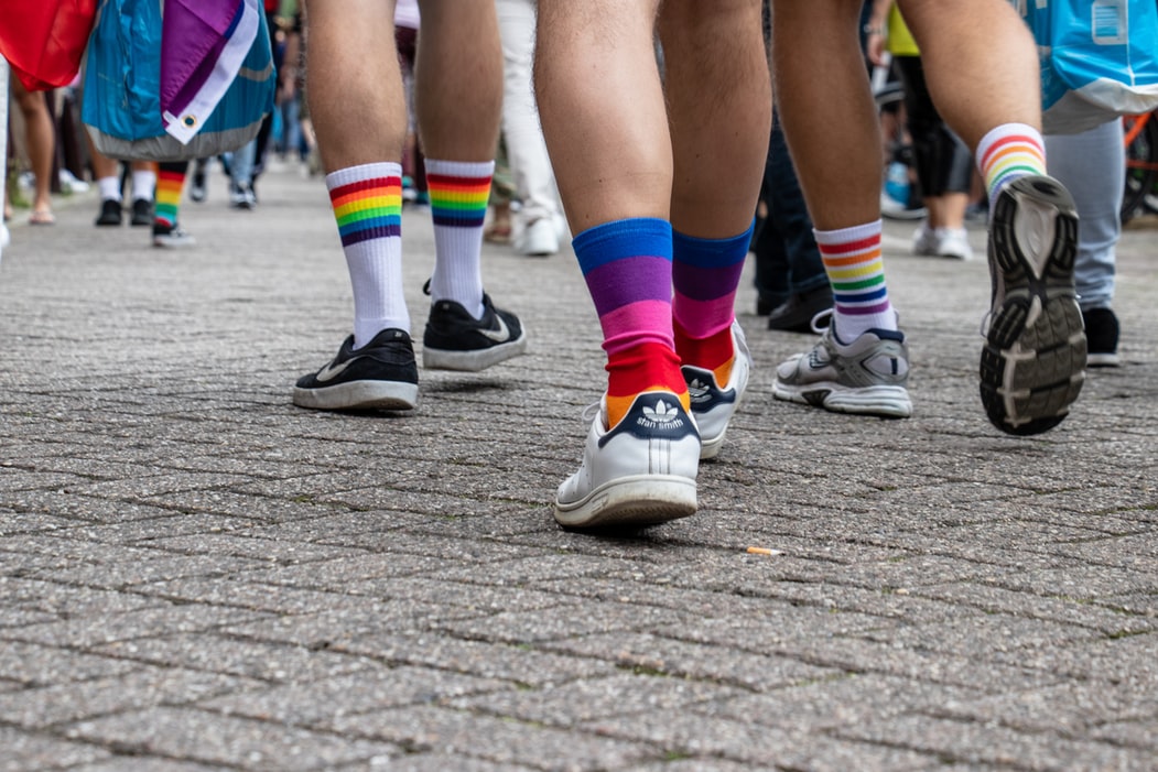 photo of a group of people wearing rainbow socks by angelacompagnone @ unsplash.com