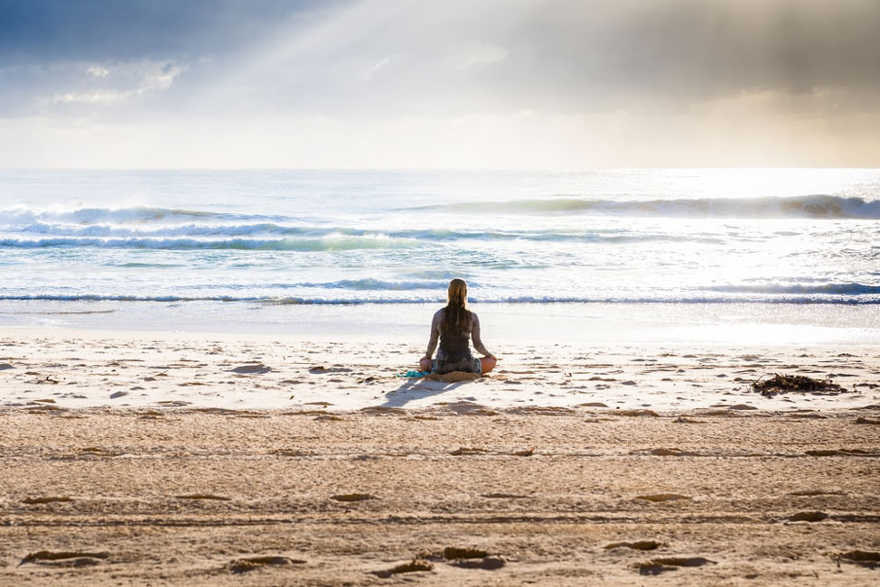 woman doing yoga at the beach by herself photo by simon rae @ unsplash.com